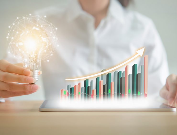 Businesswoman holding light bulb with innovative and creativity are keys to success. chart showing business growth on tablet. positive indication of income.